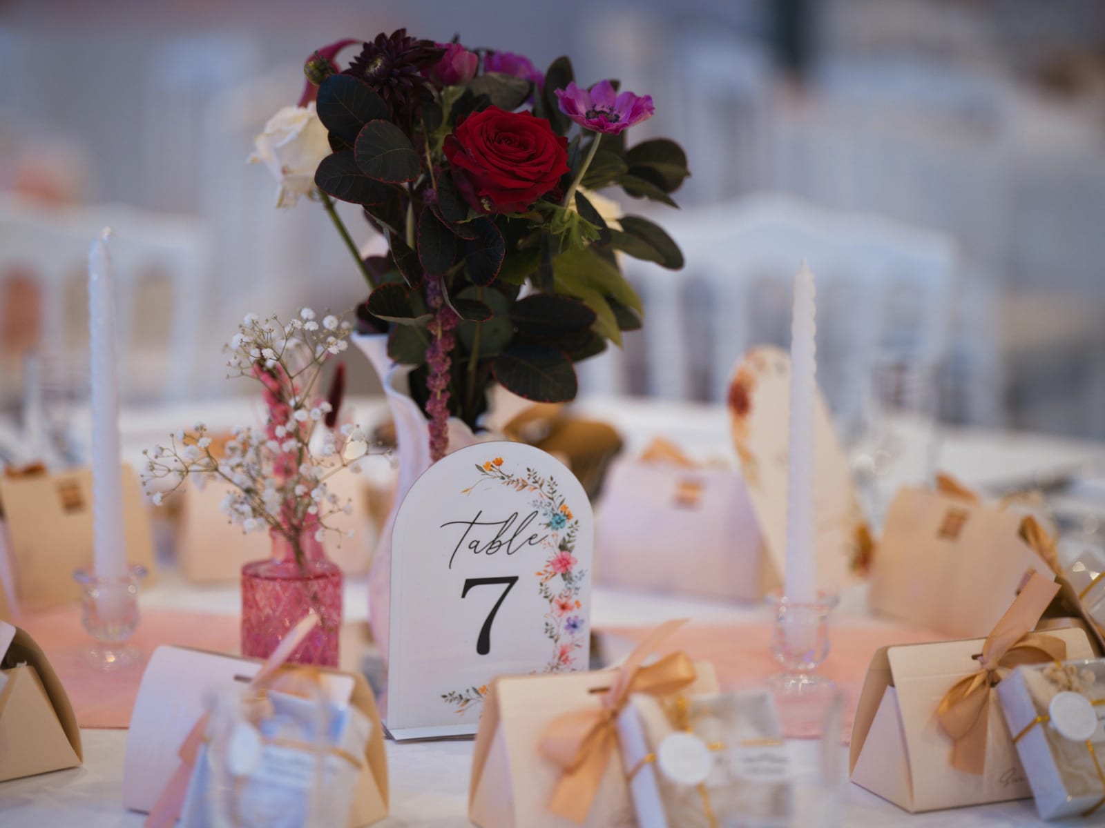 Table 7 dressée : bouquet de rose rouge et anémone, bougies blanches torsadées, vase rose, boîtes à ruban doré, mariage au Clos d'Amblaincourt, par Jean-Baptiste Argyre (Jaysphotography)