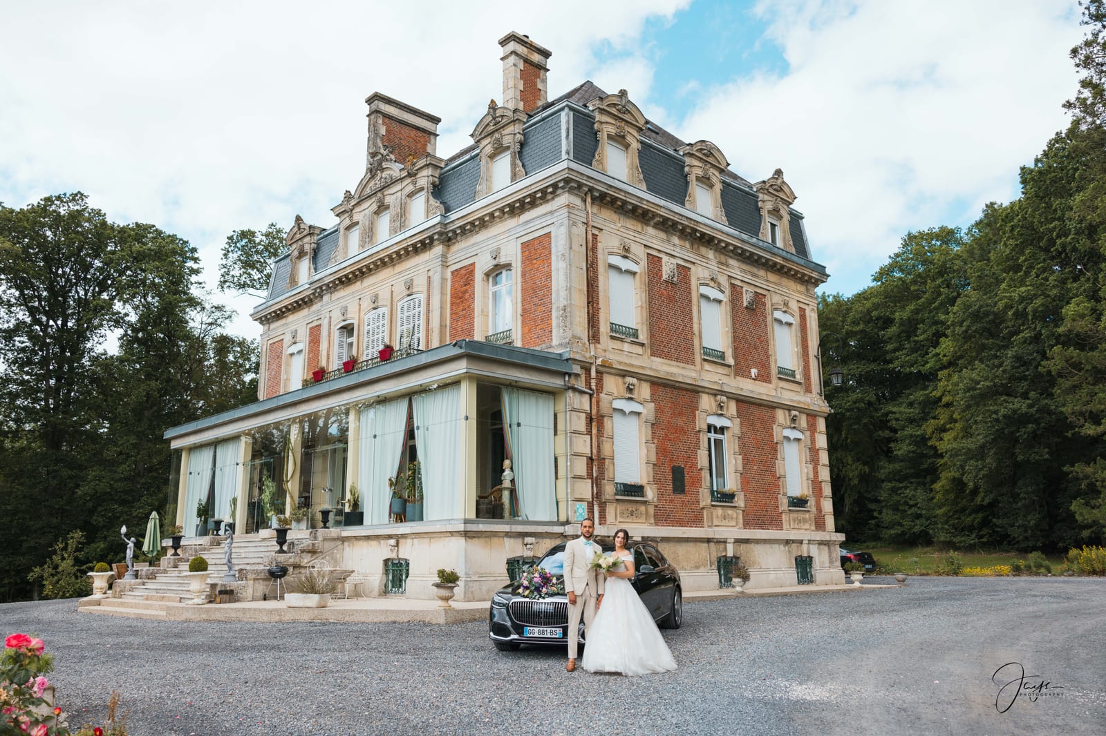 Façade du Château de Broyes en brique rouge et toiture ardoise, allée d'arrivée, ciel nuageux d'été, mariage au Château de Broyes, par Jean-Baptiste Argyre (Jaysphotography)
