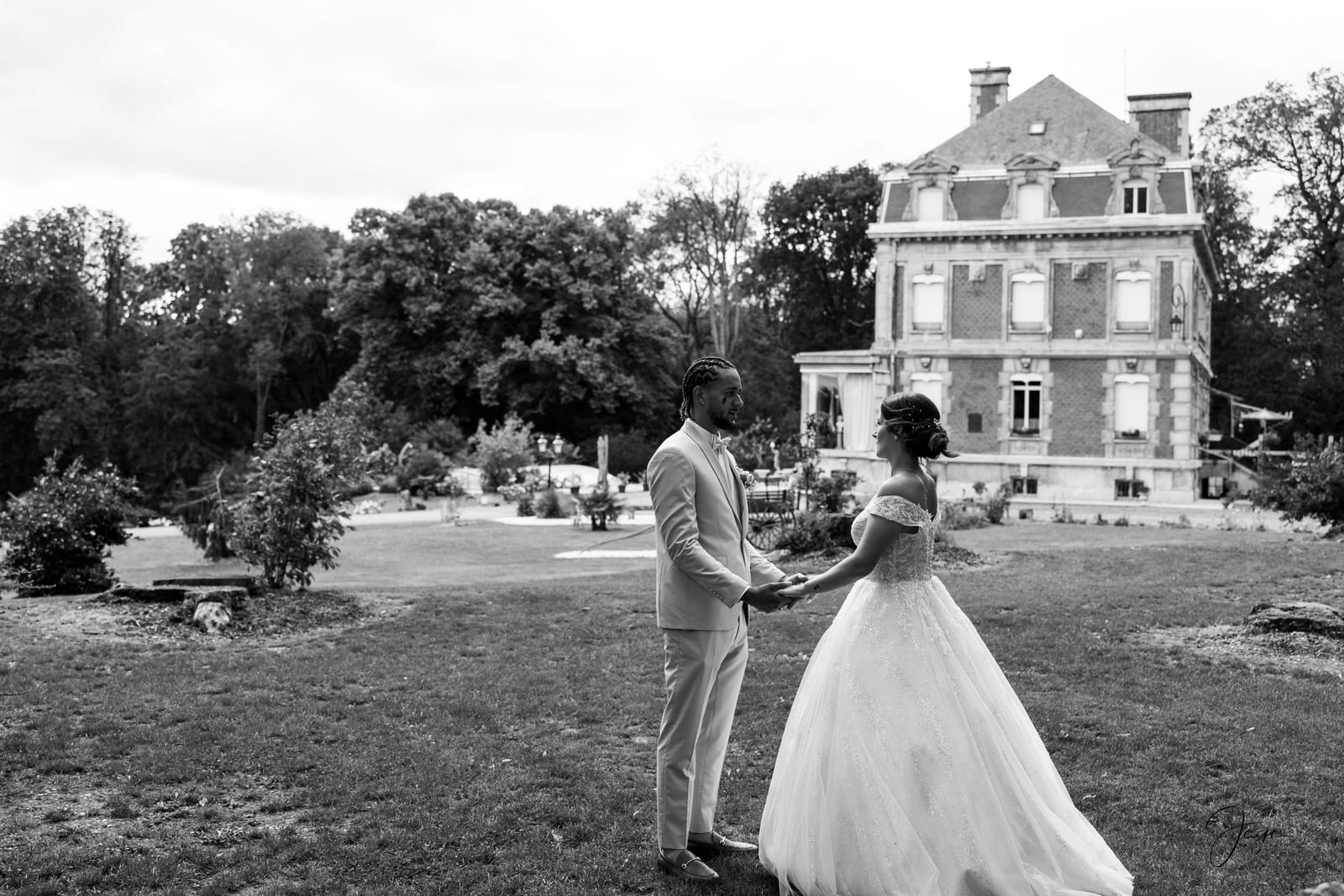 Couple N&B face à la façade du château, Marie regardant Benjamin, lumière douce d'été, mariage au Château de Broyes, par Jean-Baptiste Argyre (Jaysphotography)
