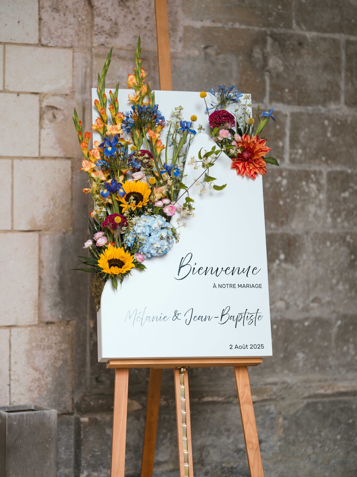 Le panneau de bienvenue fleuri de tournesols de Mélanie et Jean-Baptiste, mariage au Abbaye de Longpont & Paris, par Jean-Baptiste Argyre (Jaysphotography)