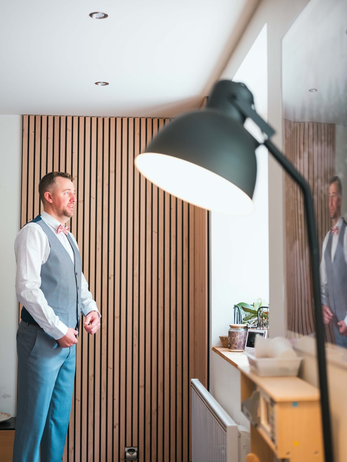 Mickael de dos devant une armoire en bois, préparatifs dans le Val-d'Oise, mariage au Domaine de la Muette, par Jean-Baptiste Argyre (Jaysphotography)