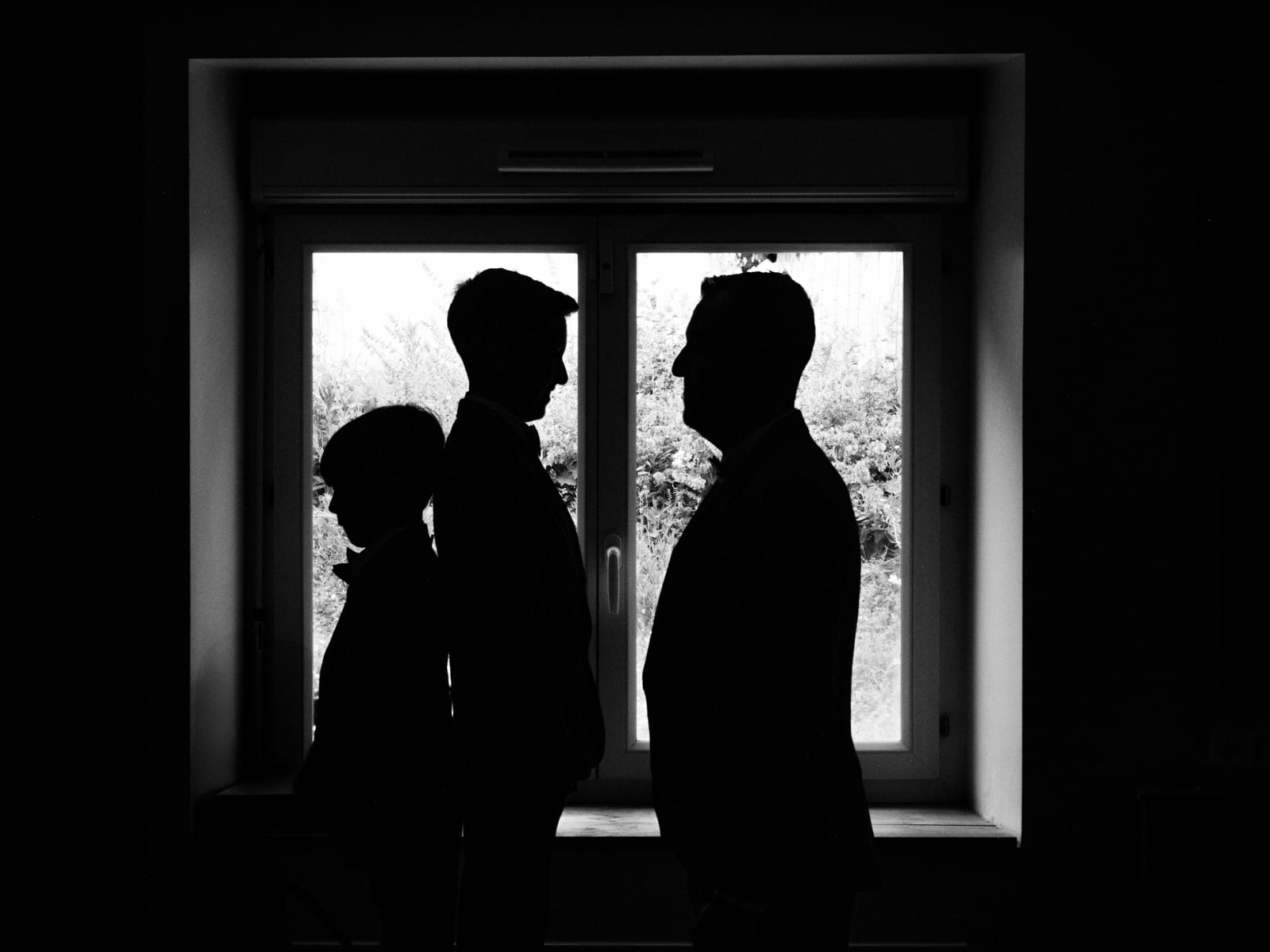 Silhouette du couple face à une grande fenêtre en contre-jour, image intimiste, mariage au Domaine de la Muette, par Jean-Baptiste Argyre (Jaysphotography)