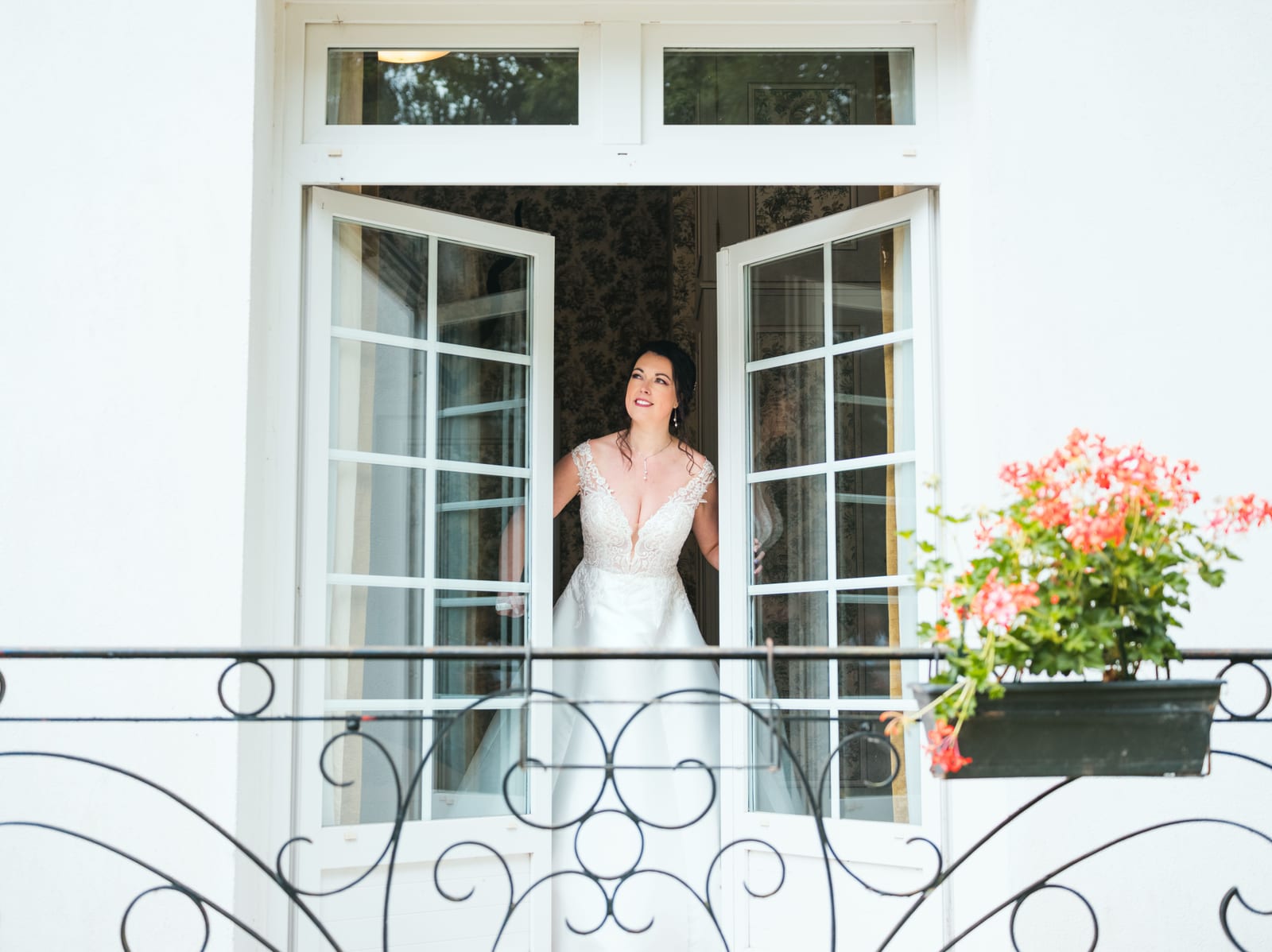 Mélissa en robe de mariée debout à la fenêtre intérieure, lumière naturelle, mariage au Domaine de la Muette, par Jean-Baptiste Argyre (Jaysphotography)