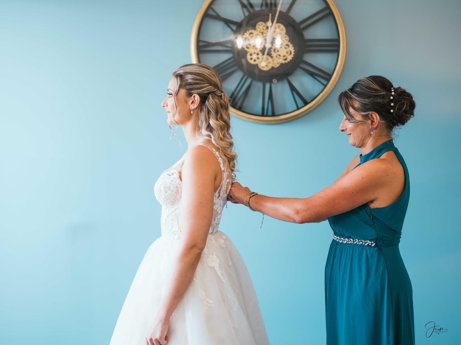 Ophélie aidée par une demoiselle d'honneur en bleu lors des préparatifs, robe à bretelles fines et corsage dentelle, mariage au Domaine de Monceaux, par Jean-Baptiste Argyre (Jaysphotography)