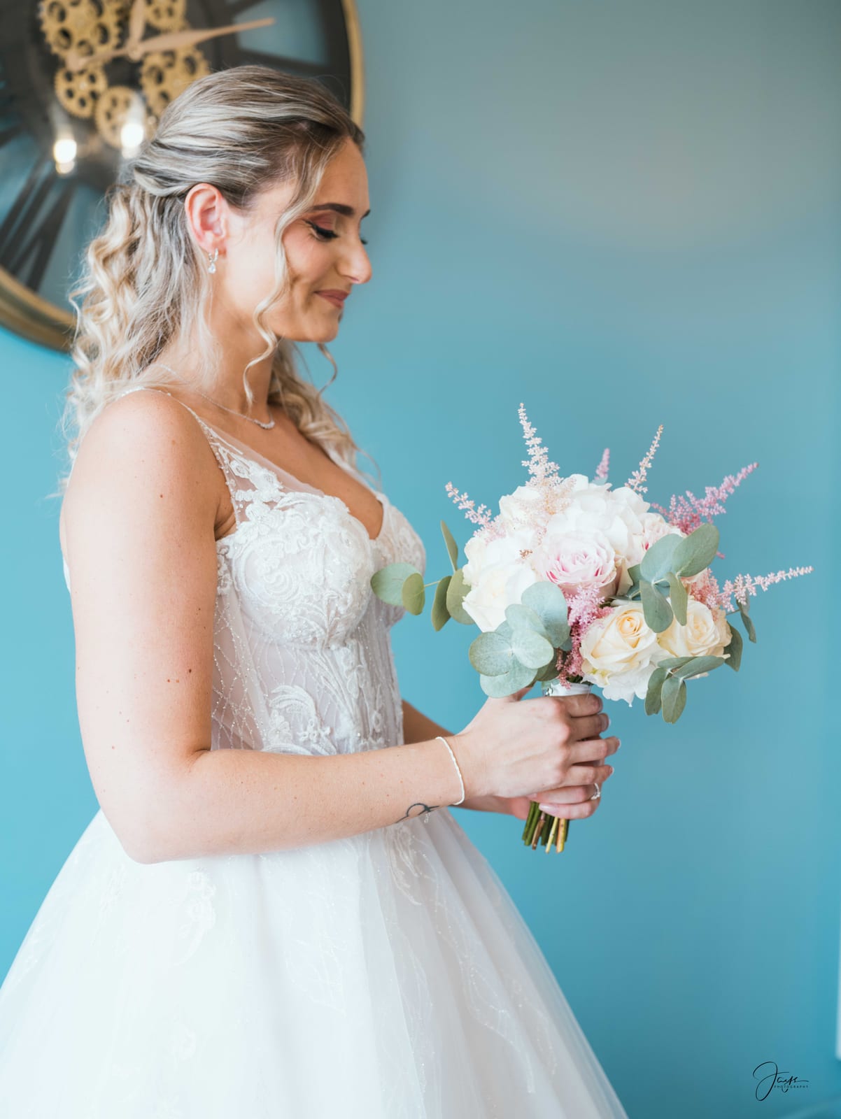 Ophélie tenant son bouquet blanc et vert, portrait face à l'objectif, robe à bretelles et corsage dentelle, mariage au Domaine de Monceaux, par Jean-Baptiste Argyre (Jaysphotography)