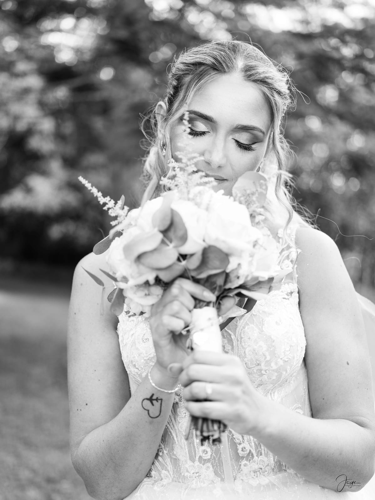 Portrait N&B d'Ophélie tenant son bouquet, expression douce et lumière contrastée, mariage au Domaine de Monceaux, par Jean-Baptiste Argyre (Jaysphotography)