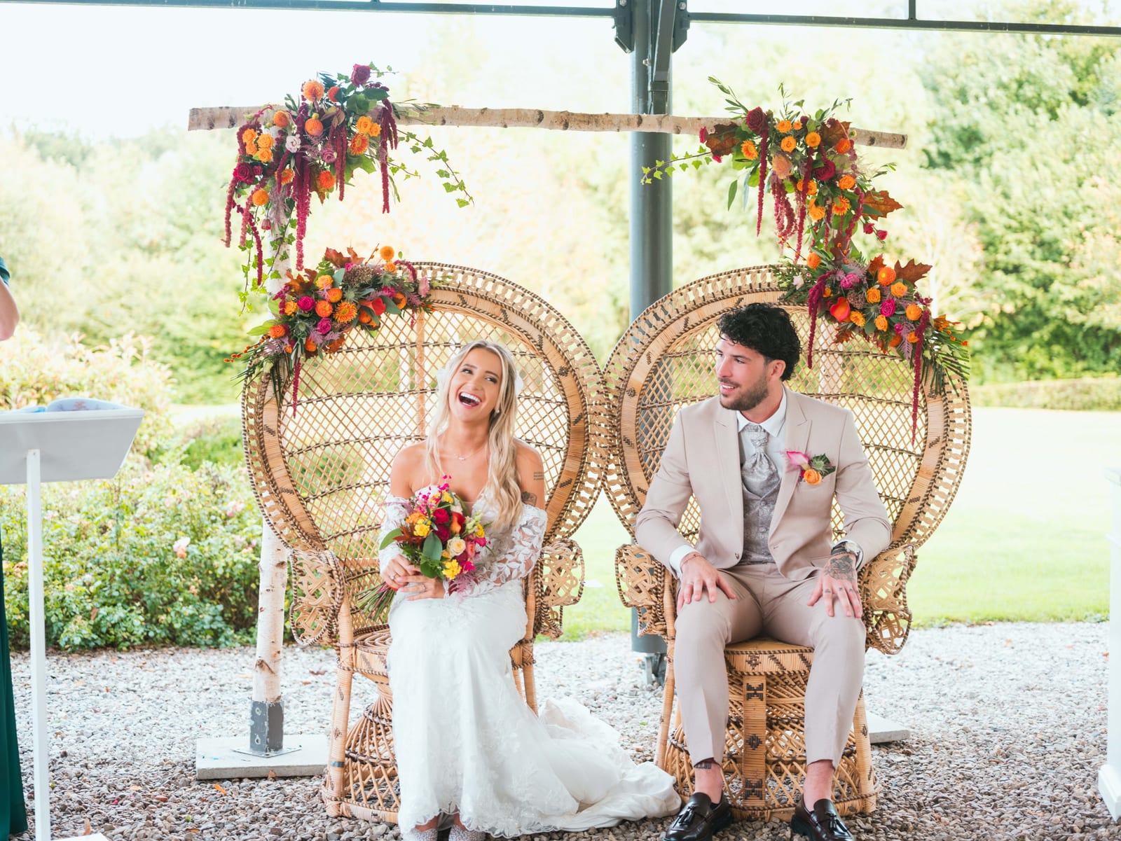 L'arche florale en cercle ornée de fleurs vives encadre les mariés pendant la cérémonie laïque, mariage au Château de la Trye, par Jean-Baptiste Argyre (Jaysphotography)