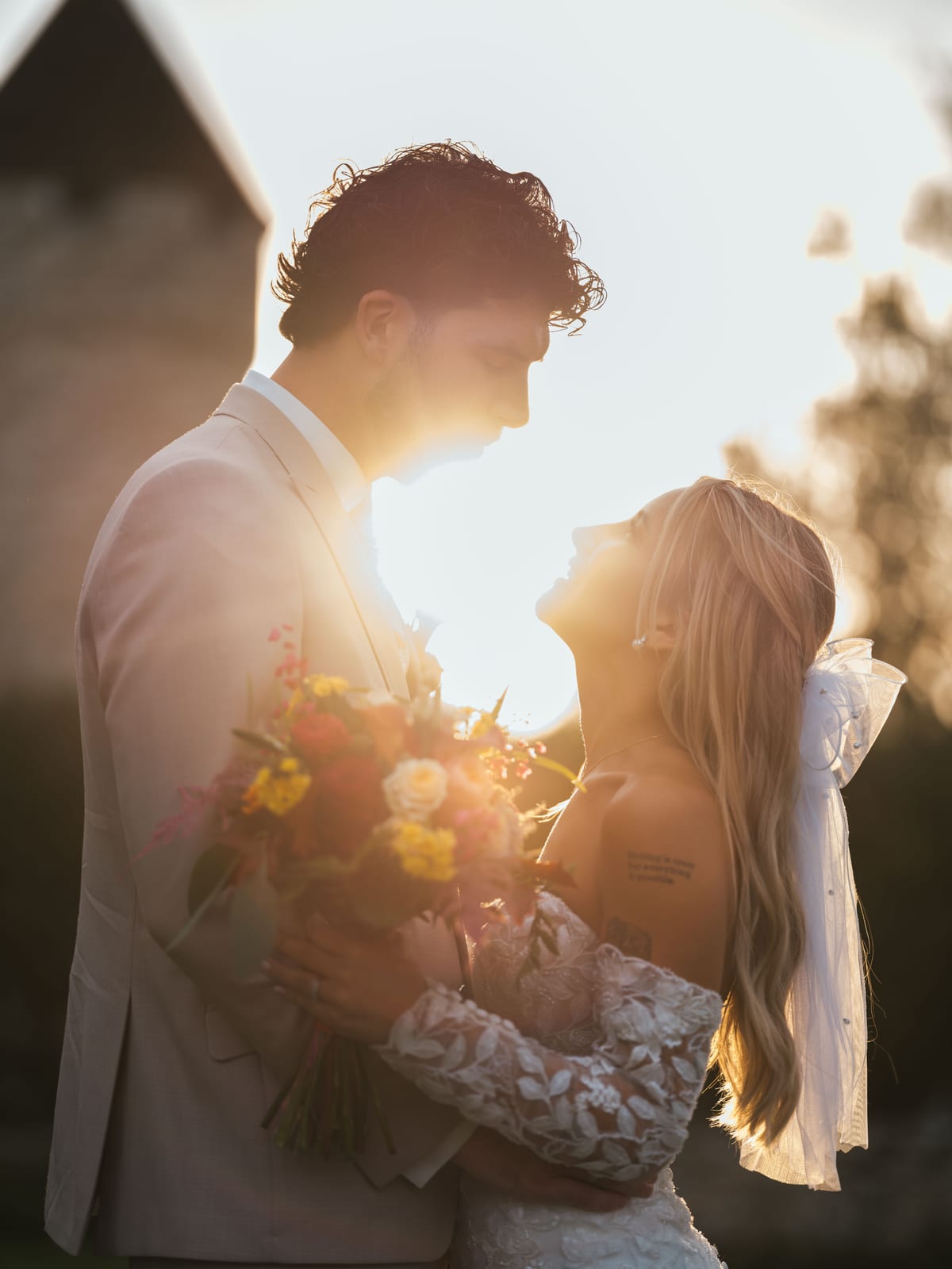 Pauline et Benjamin enlacés, soleils couchant formant un halo doré entre eux, mariage au Château de la Trye, par Jean-Baptiste Argyre (Jaysphotography)