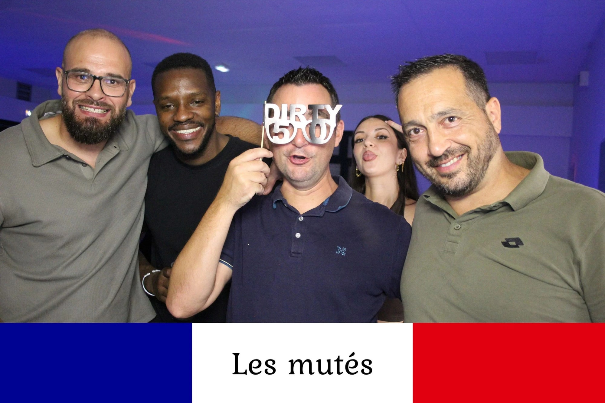 Quatre invités serrés autour d'un homme qui porte des lunettes en carton Dirty 50, éclairage bleu de la piste, mariage à la Salle des fêtes de Saint-Sauveur (Oise), par Jean-Baptiste Argyre (Jaysphotography)