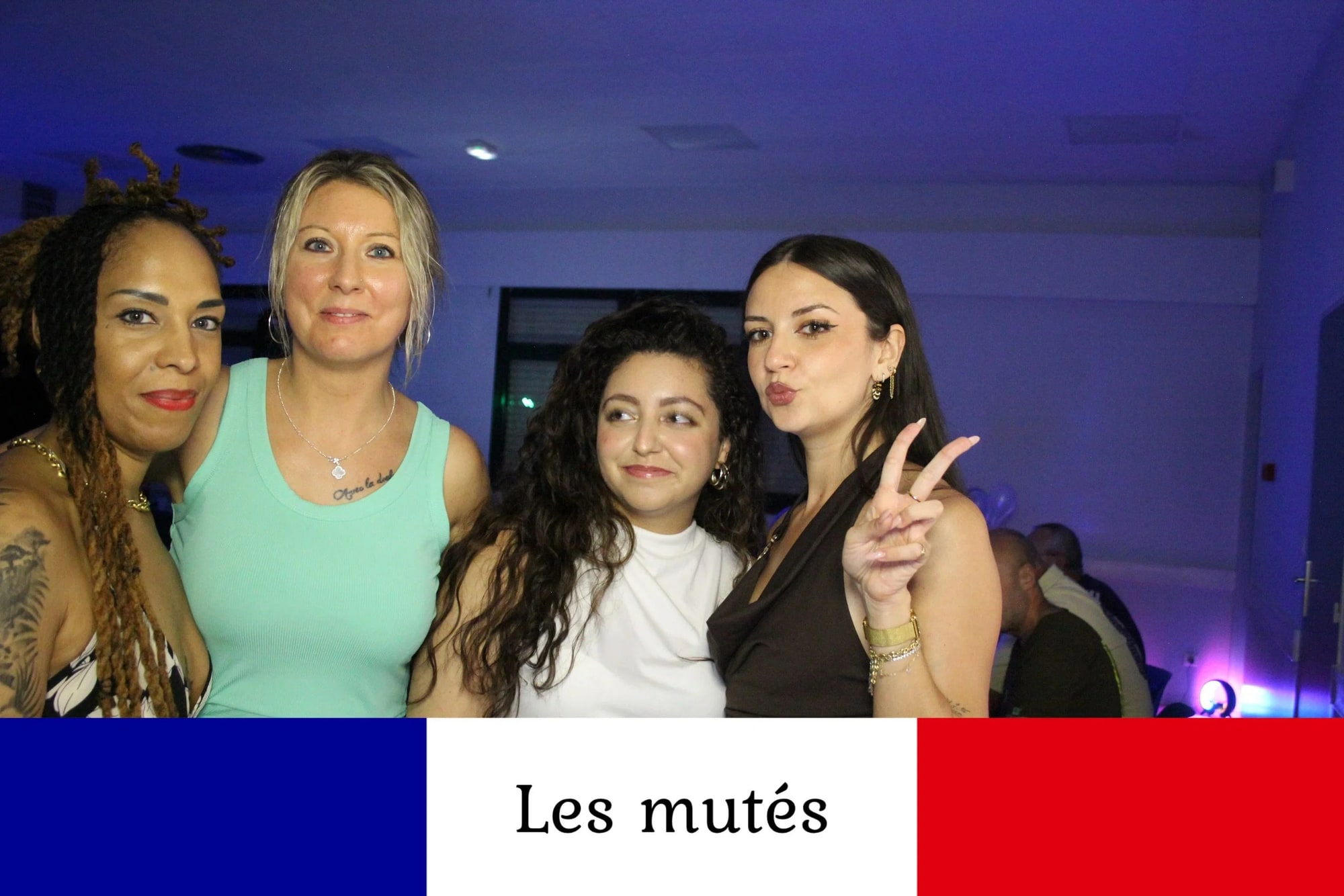 Quatre invitées alignées face à la borne, bouche en cœur et doigts en V, salle éclairée en bleu, mariage à la Salle des fêtes de Saint-Sauveur (Oise), par Jean-Baptiste Argyre (Jaysphotography)