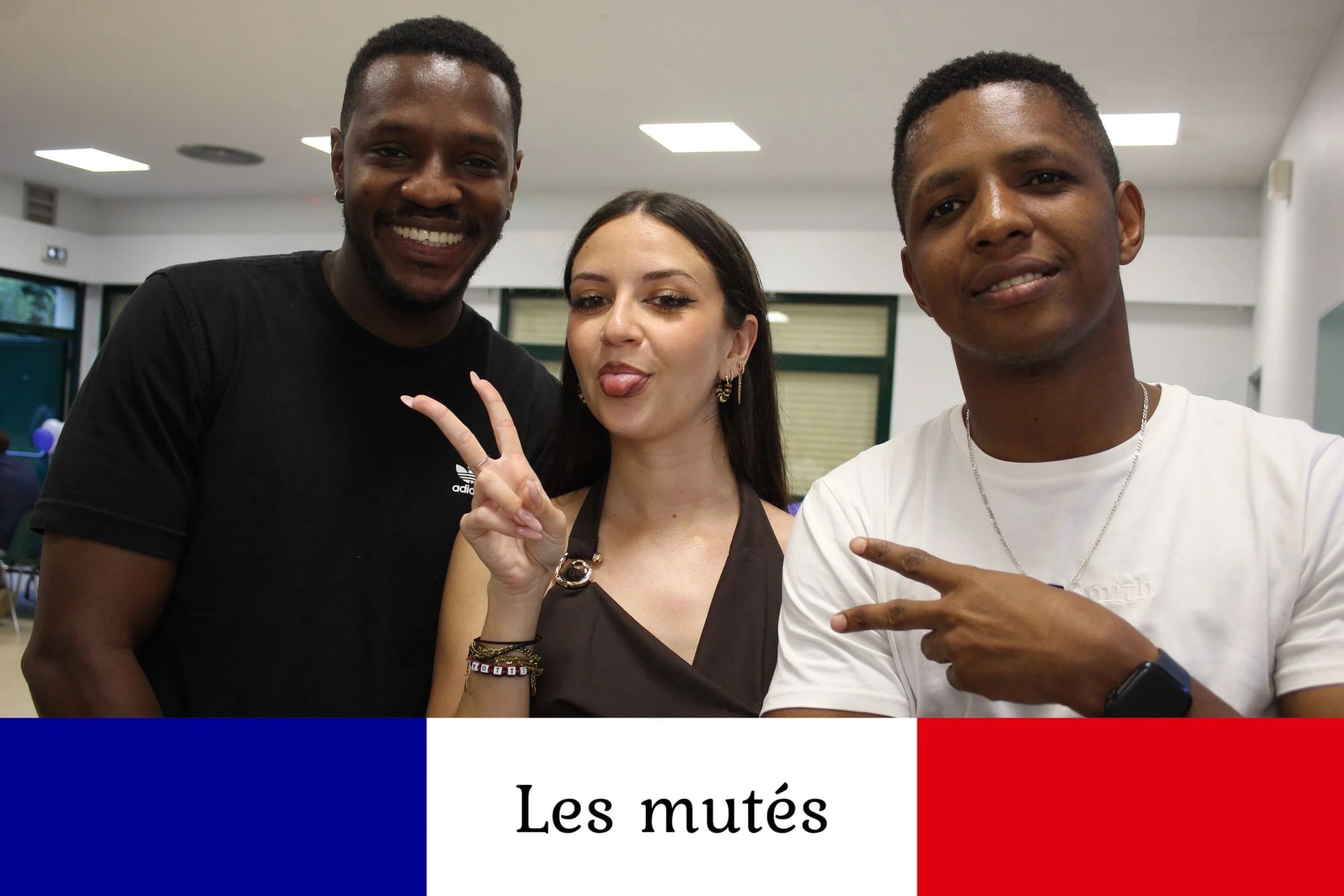 Trois invités posent à la borne en début de soirée, salle encore éclairée au néon, doigts en V, mariage à la Salle des fêtes de Saint-Sauveur (Oise), par Jean-Baptiste Argyre (Jaysphotography)
