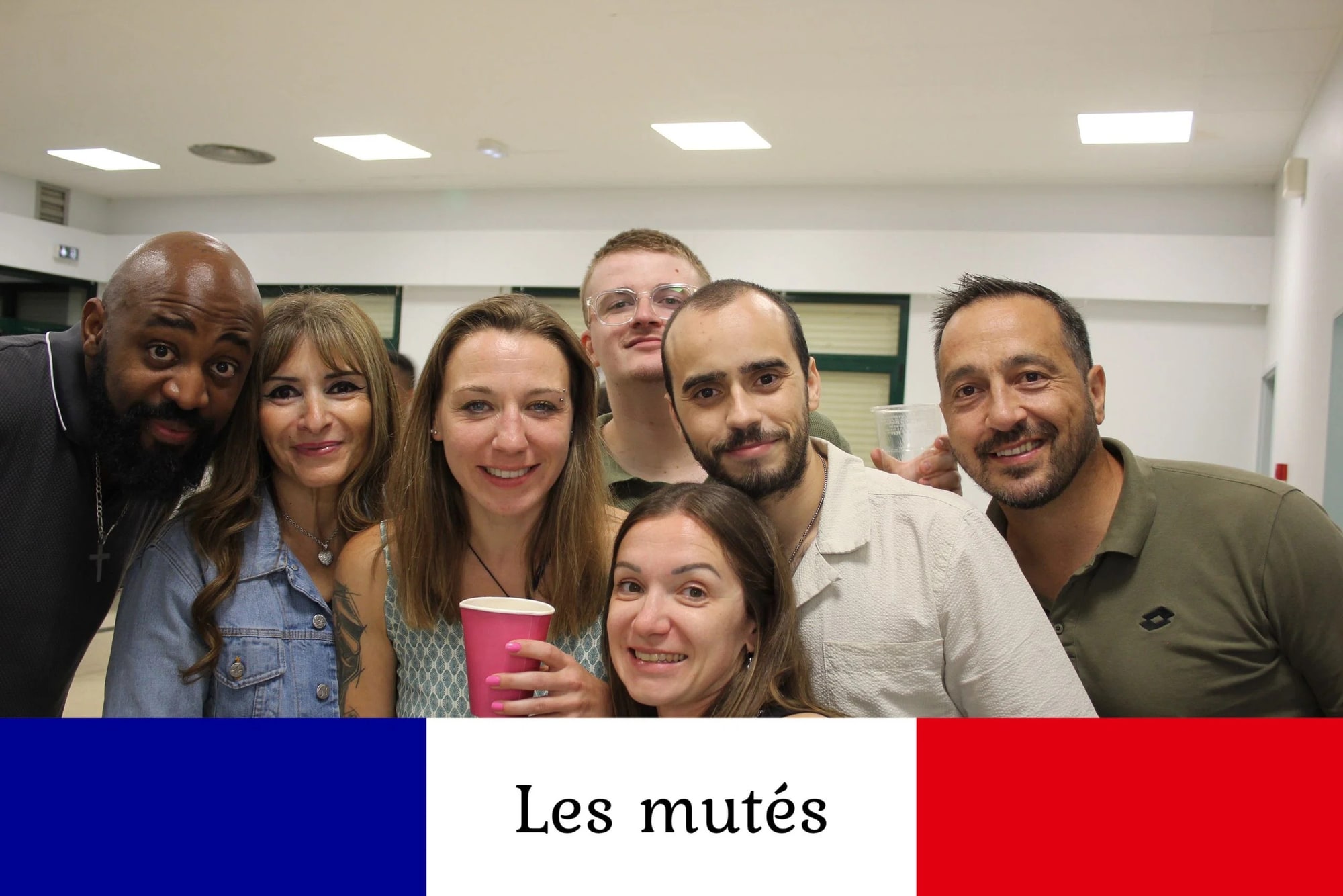 Sept invités serrés dans le cadre, gobelets à la main, en fin de service de la borne, mariage à la Salle des fêtes de Saint-Sauveur (Oise), par Jean-Baptiste Argyre (Jaysphotography)