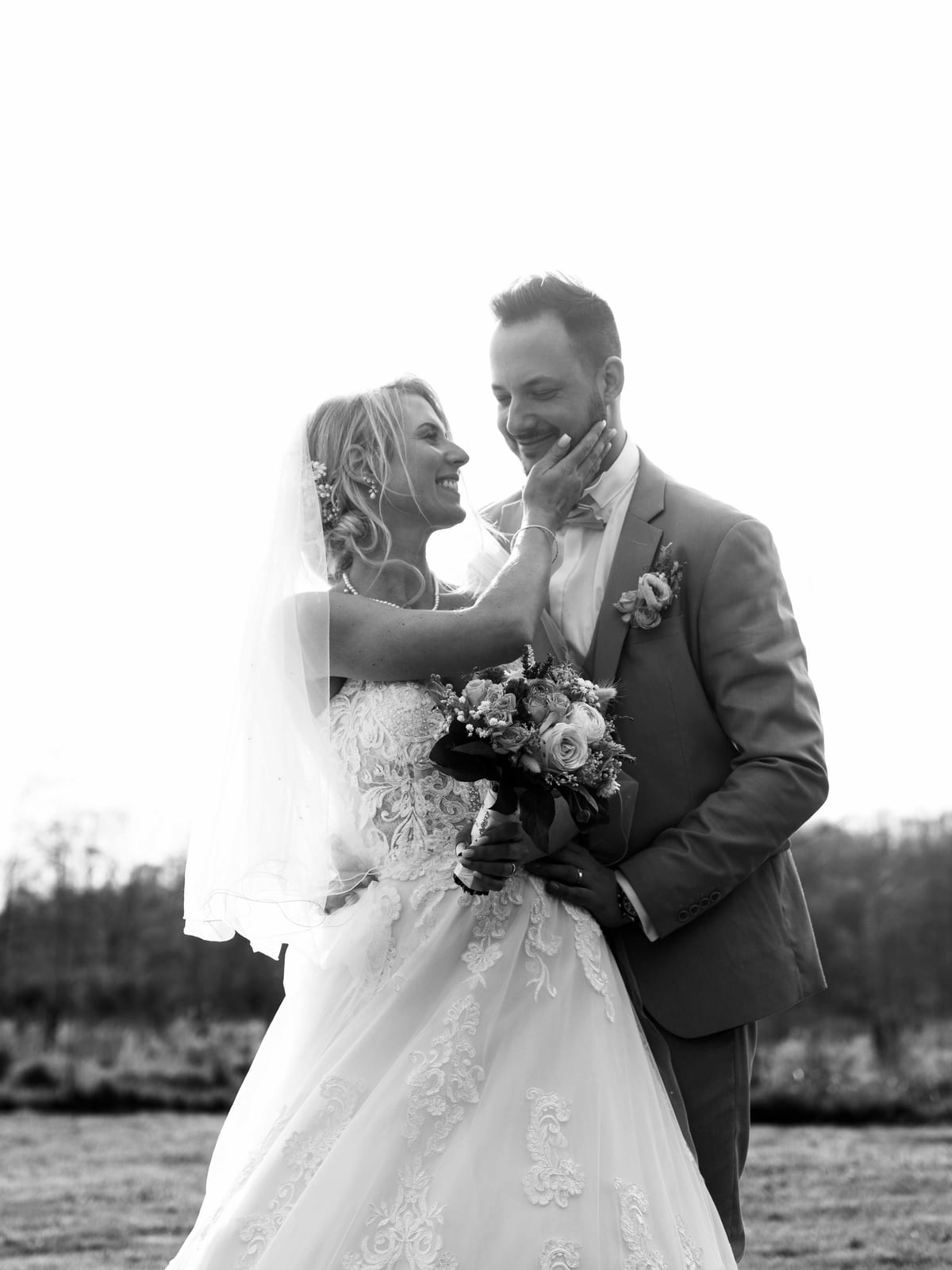 Portrait en noir et blanc du couple enlacé, Romain et Julie, lac du Domaine des Saules en arrière-plan, mariage au Domaine des Saules, par Jean-Baptiste Argyre (Jaysphotography)