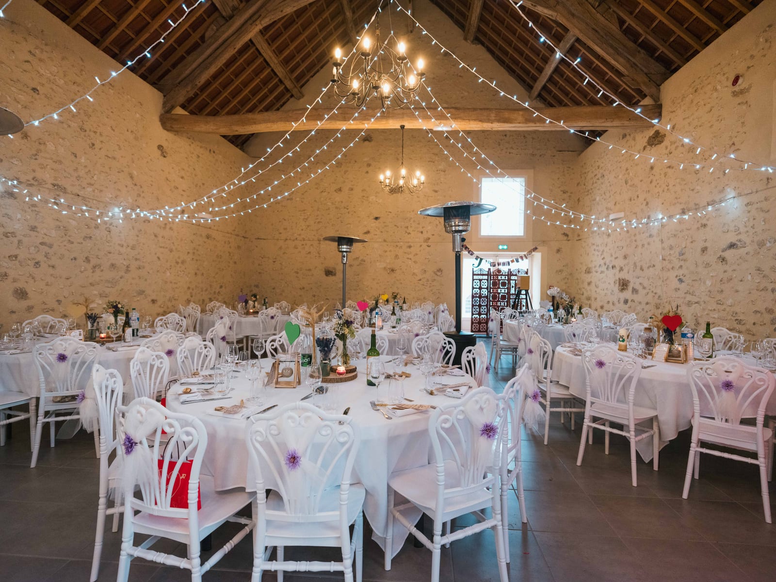 Salle de réception du Domaine des Saules décorée de guirlandes lumineuses, tables blanches et chaises Chiavari, mariage au Domaine des Saules, par Jean-Baptiste Argyre (Jaysphotography)