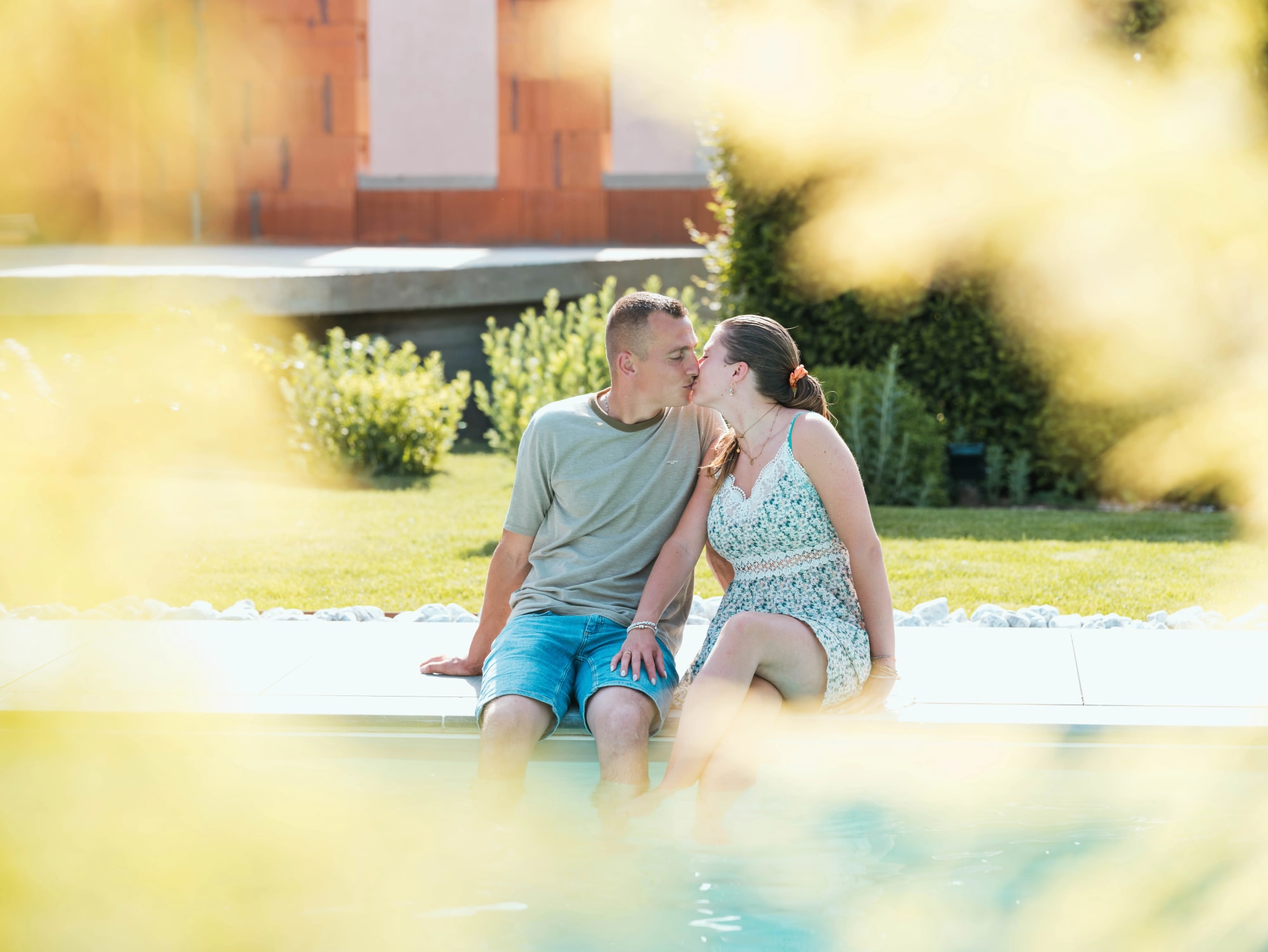 Baiser d'Amélie et Guillaume assis au bord de la piscine, mariage au Le jardin de la famille, avec piscine (Oise), par Jean-Baptiste Argyre (Jaysphotography)
