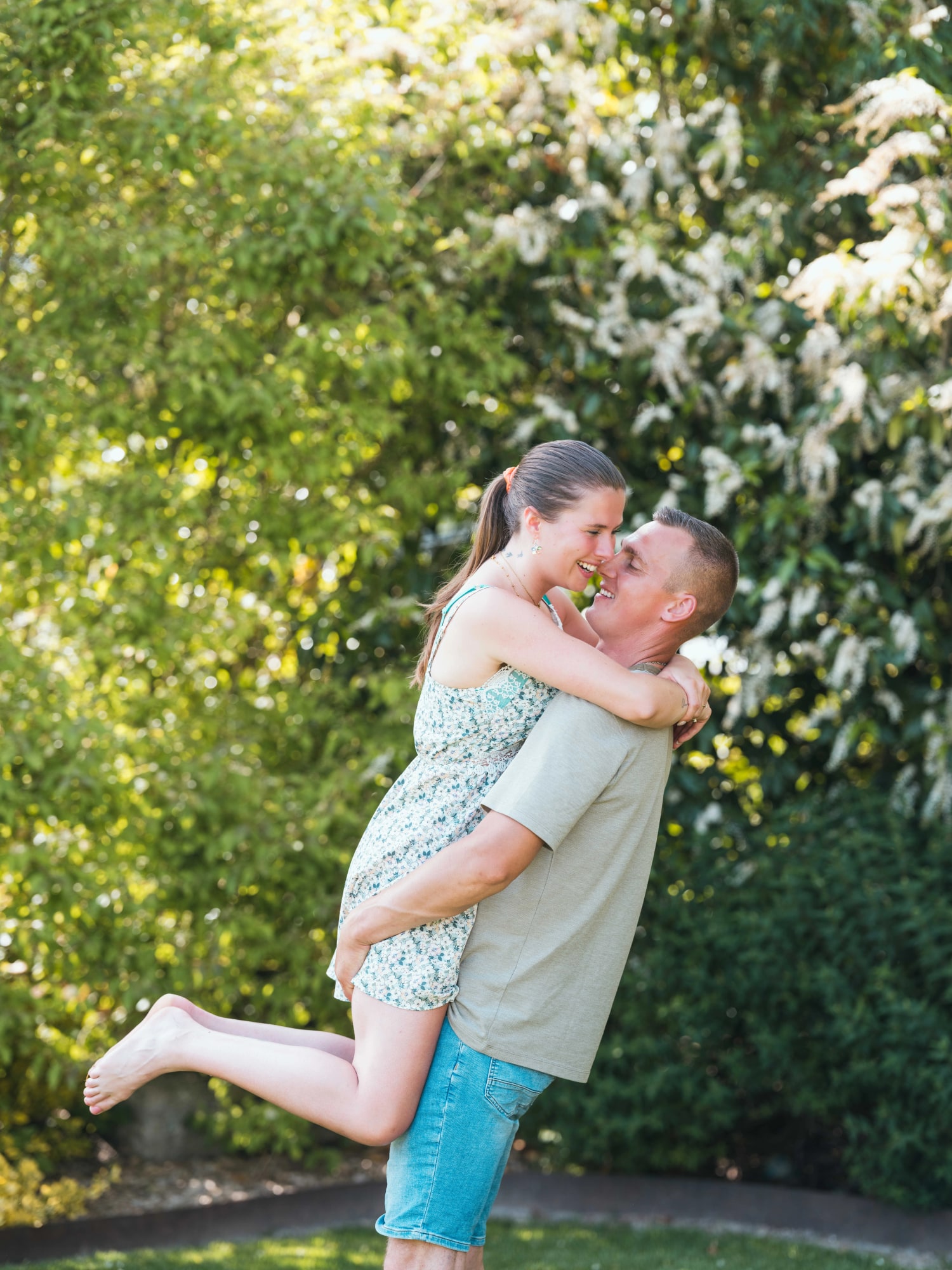 Amélie sautant dans les bras de Guillaume sur la pelouse, mariage au Le jardin de la famille, avec piscine (Oise), par Jean-Baptiste Argyre (Jaysphotography)