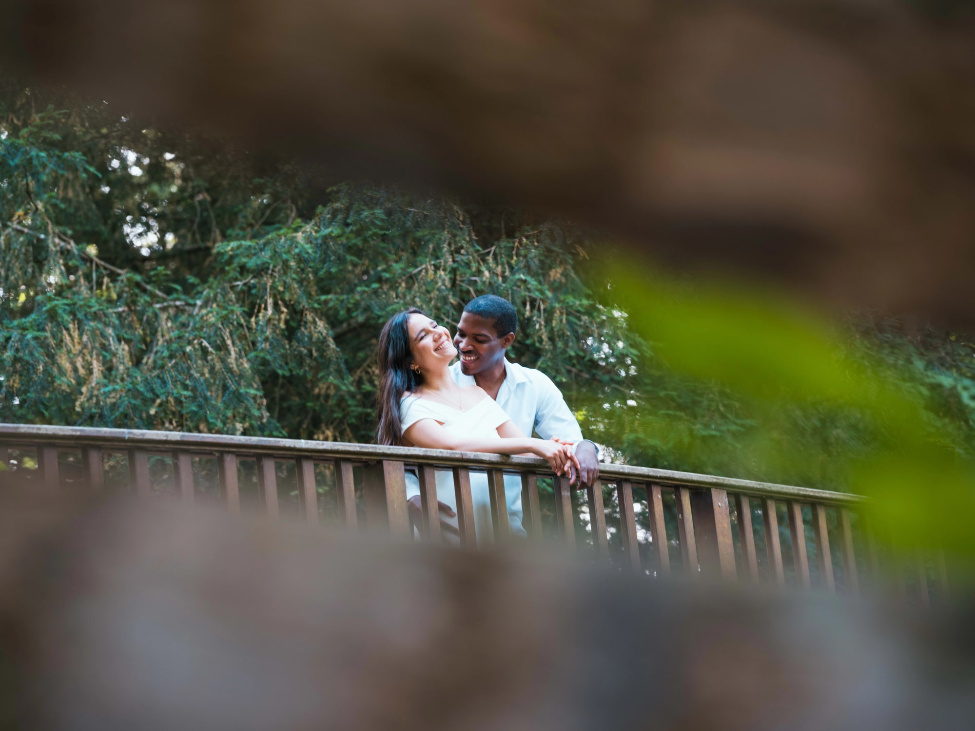 Cindy et Printis accoudés à la rambarde du pont de bois, mariage au Château de Lamorlaye, par Jean-Baptiste Argyre (Jaysphotography)
