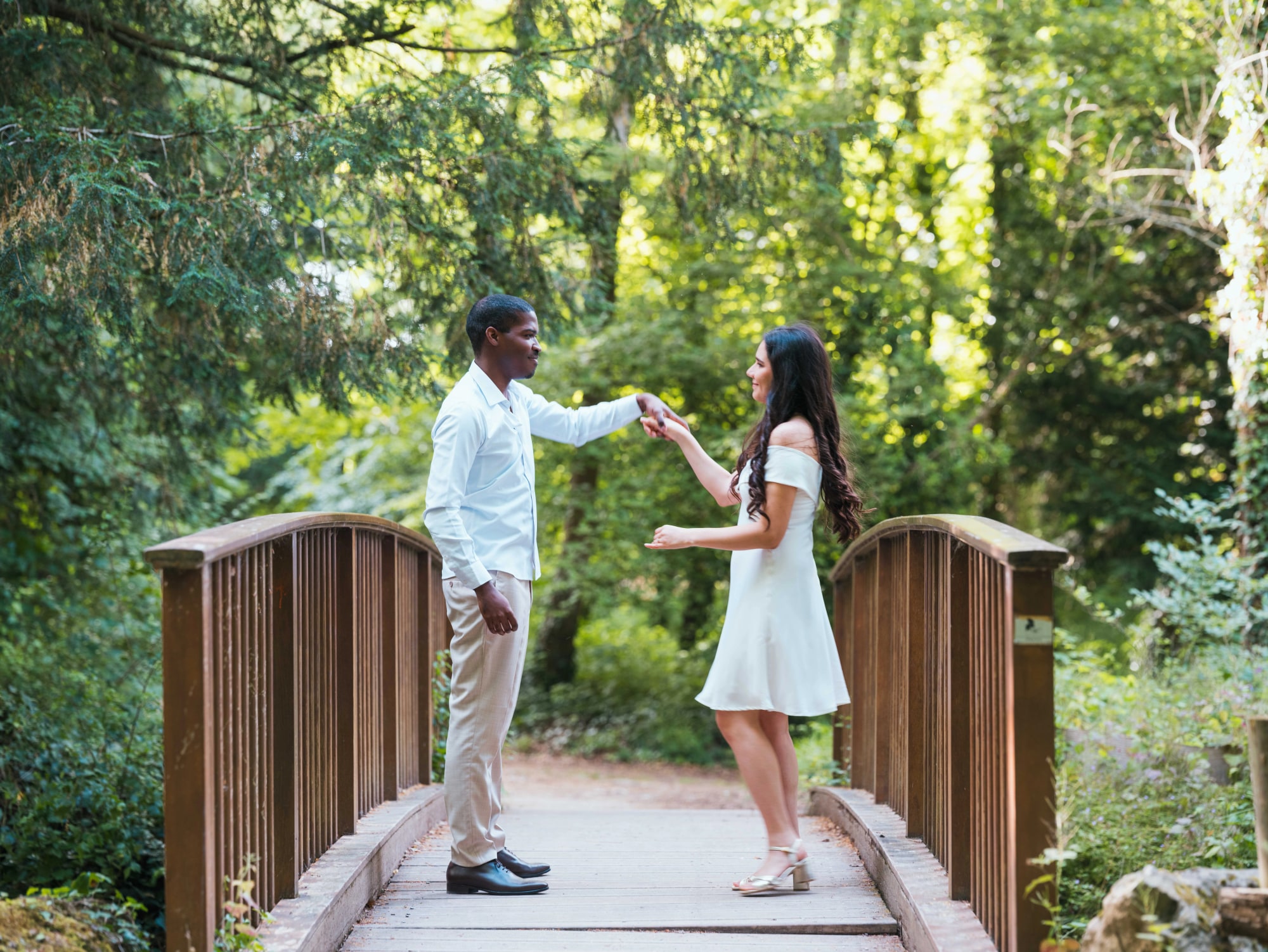 Printis tendant la main à Cindy sur le pont de bois, mariage au Château de Lamorlaye, par Jean-Baptiste Argyre (Jaysphotography)