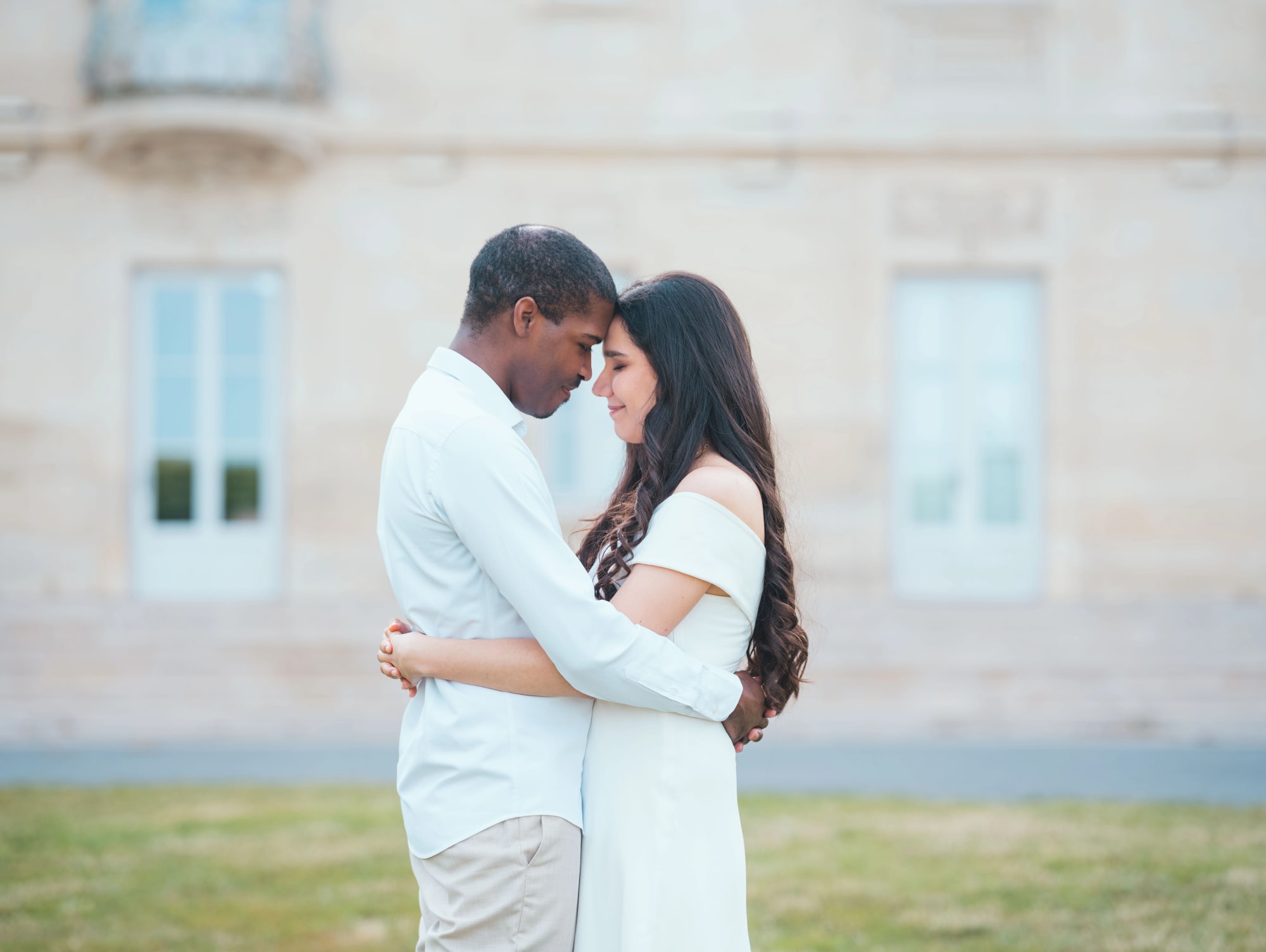 Le couple enlacé devant la façade claire du Château de Lamorlaye, mariage au Château de Lamorlaye, par Jean-Baptiste Argyre (Jaysphotography)