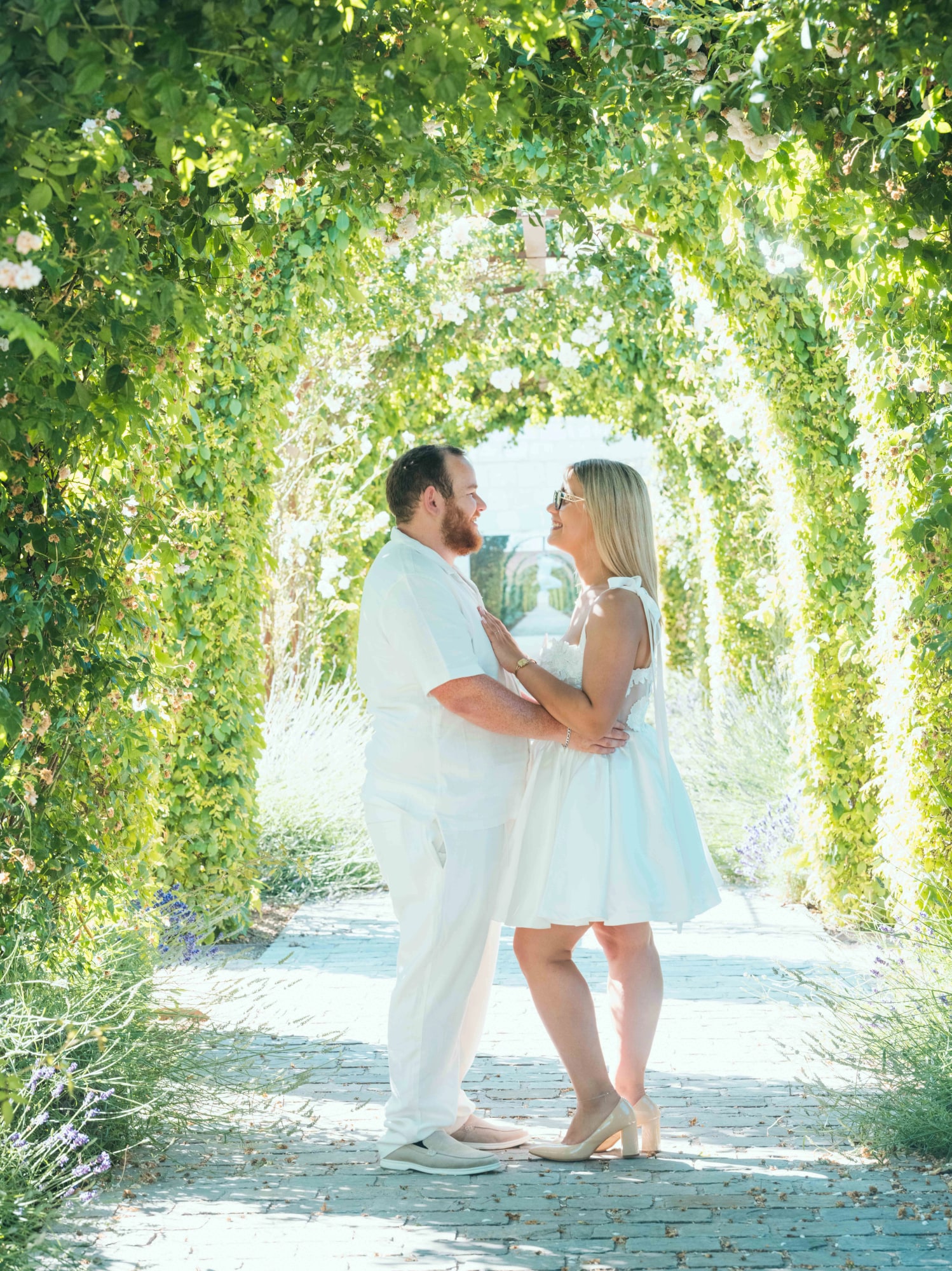 Le couple enlacé au centre de l'allée aux arceaux de verdure du jardin médiéval, mariage au Maladrerie Saint-Lazare (Beauvais), par Jean-Baptiste Argyre (Jaysphotography)