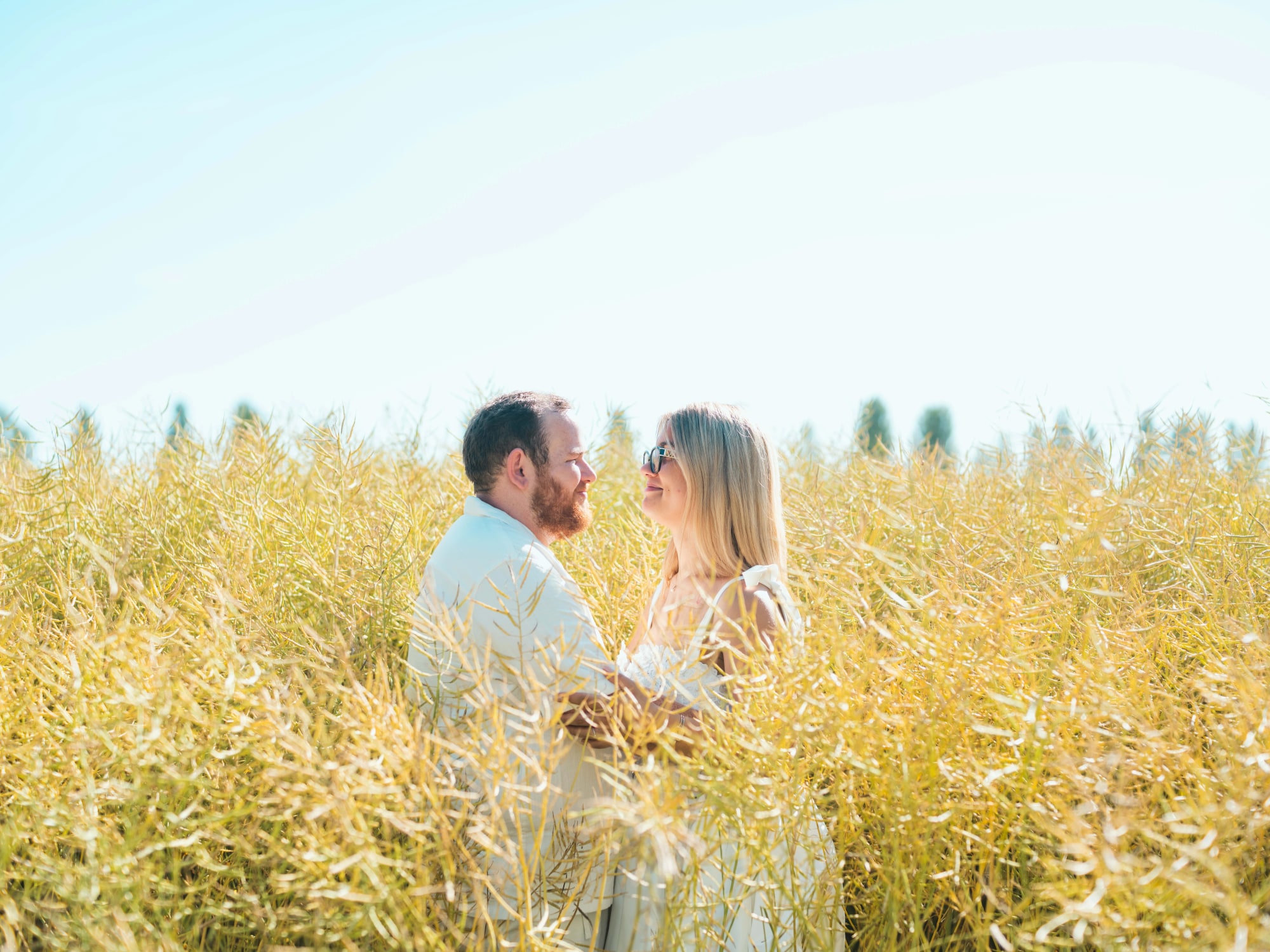 Le couple face à face dans le champ doré, mariage au Maladrerie Saint-Lazare (Beauvais), par Jean-Baptiste Argyre (Jaysphotography)