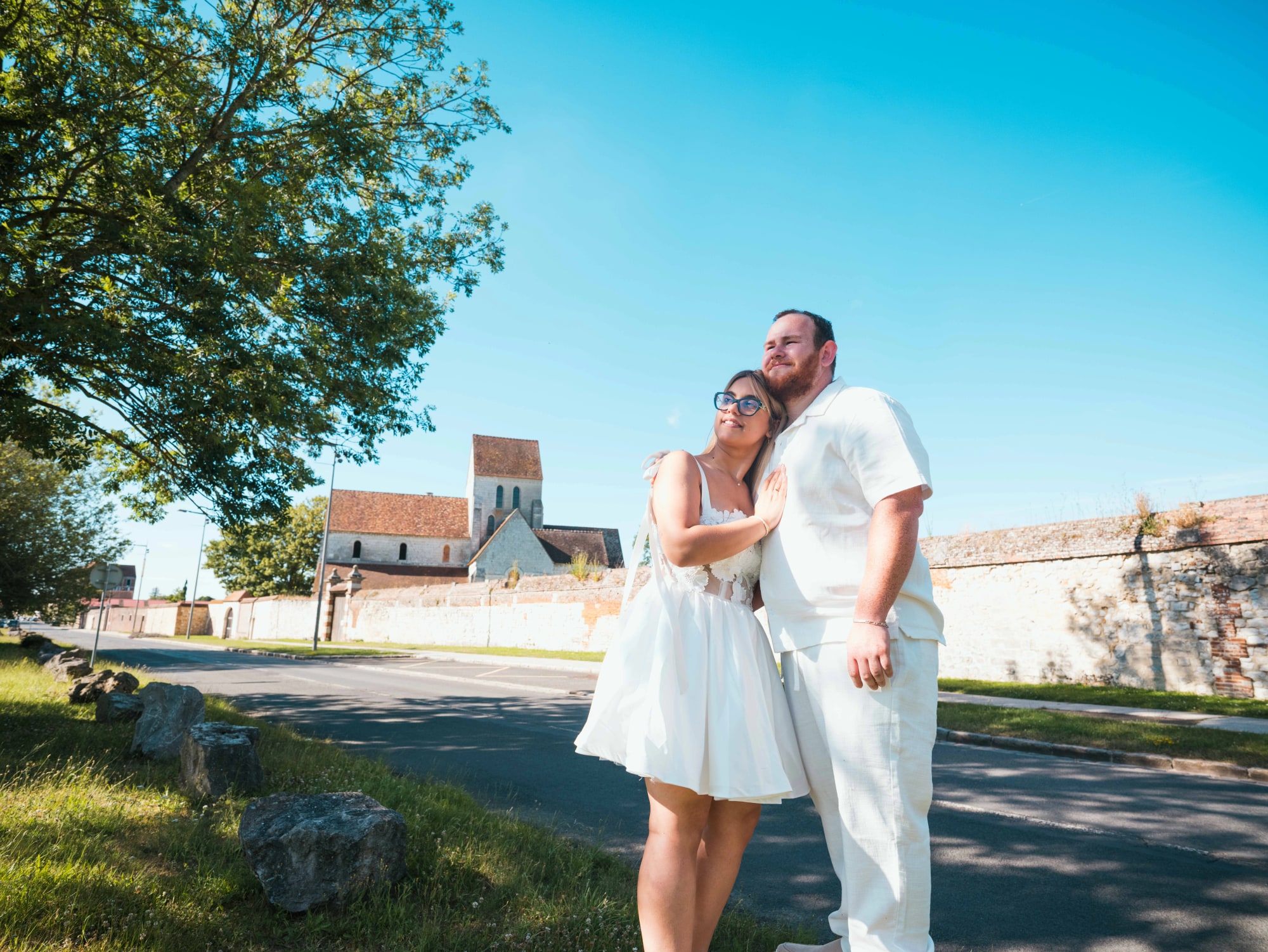Le couple sur la route, la pierre de la Maladrerie Saint-Lazare en arrière-plan, mariage au Maladrerie Saint-Lazare (Beauvais), par Jean-Baptiste Argyre (Jaysphotography)