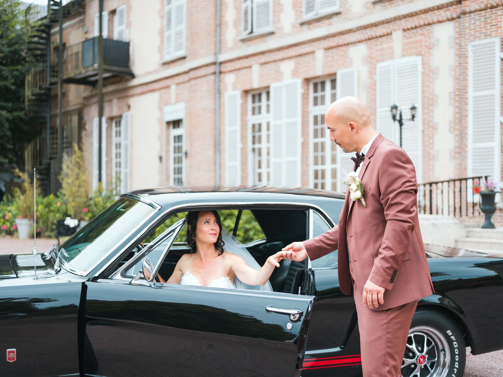 Arrivée de Stéphanie en voiture ancienne noire devant la façade du Château de la Houssoye, mariage au Château de la Houssoye, par Jean-Baptiste Argyre (Jaysphotography)
