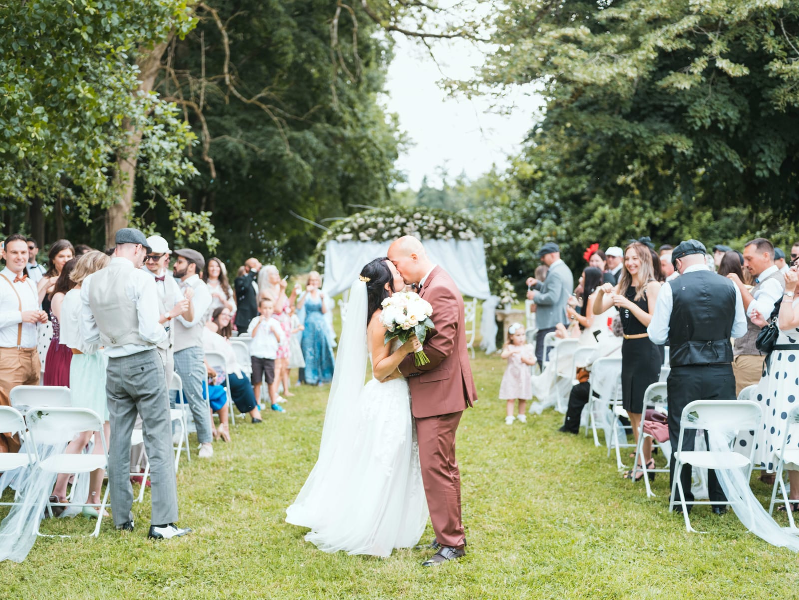 Sortie de cérémonie de Stéphanie et Fabien applaudis par leurs proches dans les jardins, mariage au Château de la Houssoye, par Jean-Baptiste Argyre (Jaysphotography)