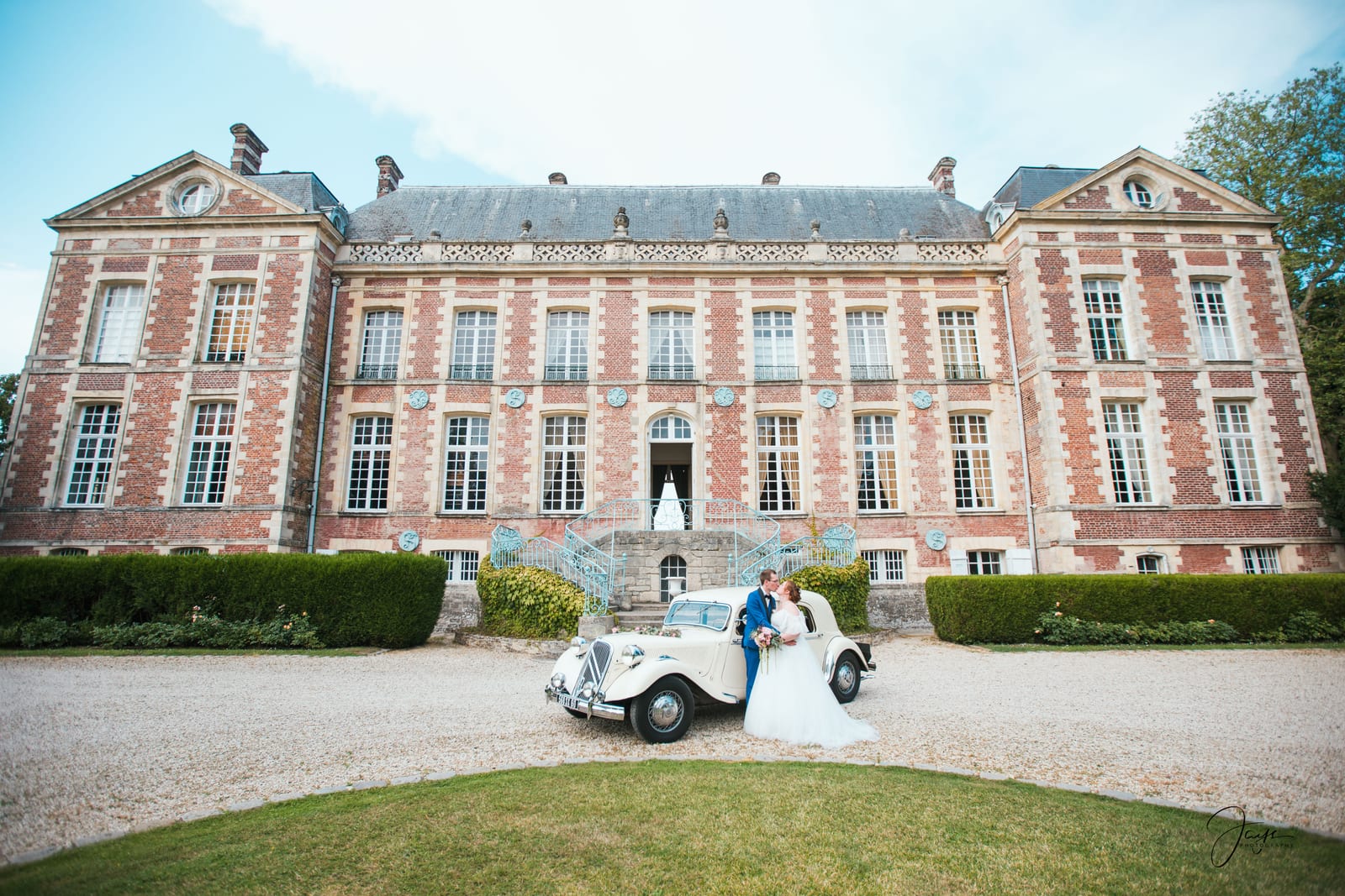 Valentine et Nicolas devant la façade en briques, végétation encadrante, mariage au Château de Sorel, par Jean-Baptiste Argyre (Jaysphotography)