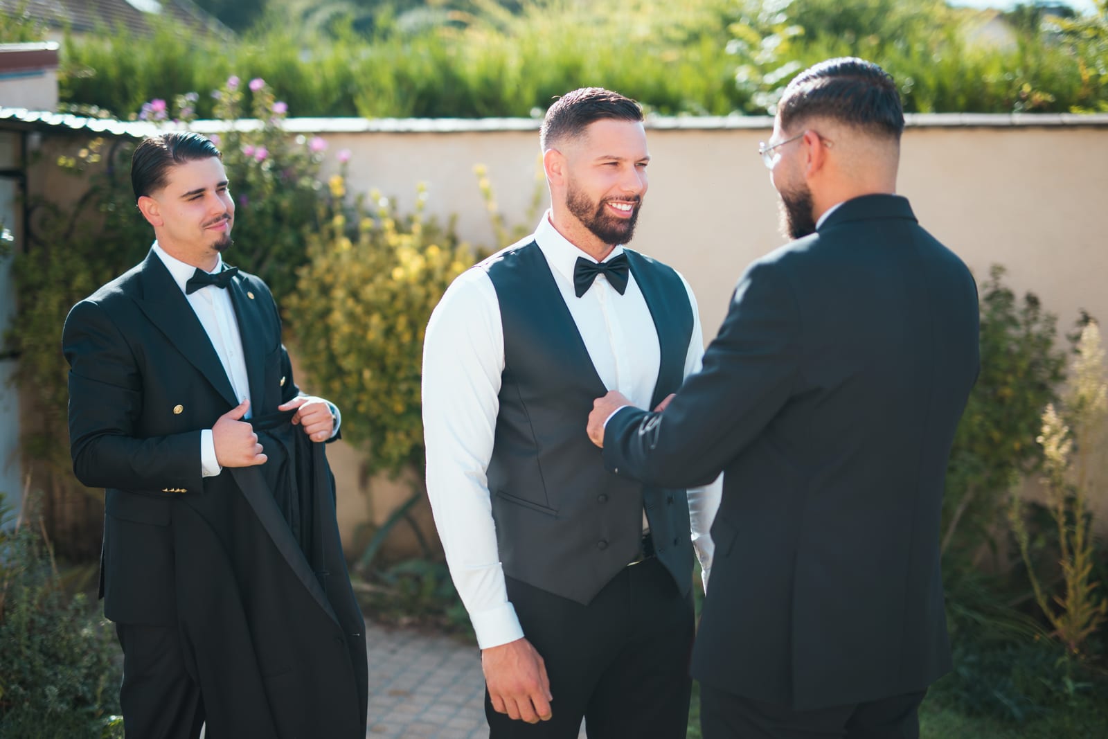 Flat-lay des détails de préparatifs de Wendy sur parquet clair : escarpins blancs, chaussures enfant avec noeuds, bouquet blanc cassé et noeud papillon noir, mariage au Château de Lamorlaye, par Jean-Baptiste Argyre (Jaysphotography)