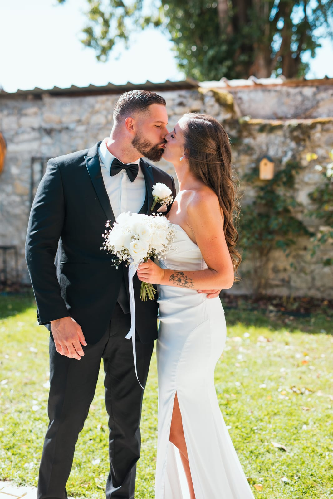 Wendy et Daniel lors du premier baiser officiel de la cérémonie civile, couple absorbé par l'instant, fond de salle flou, mariage au Château de Lamorlaye, par Jean-Baptiste Argyre (Jaysphotography)