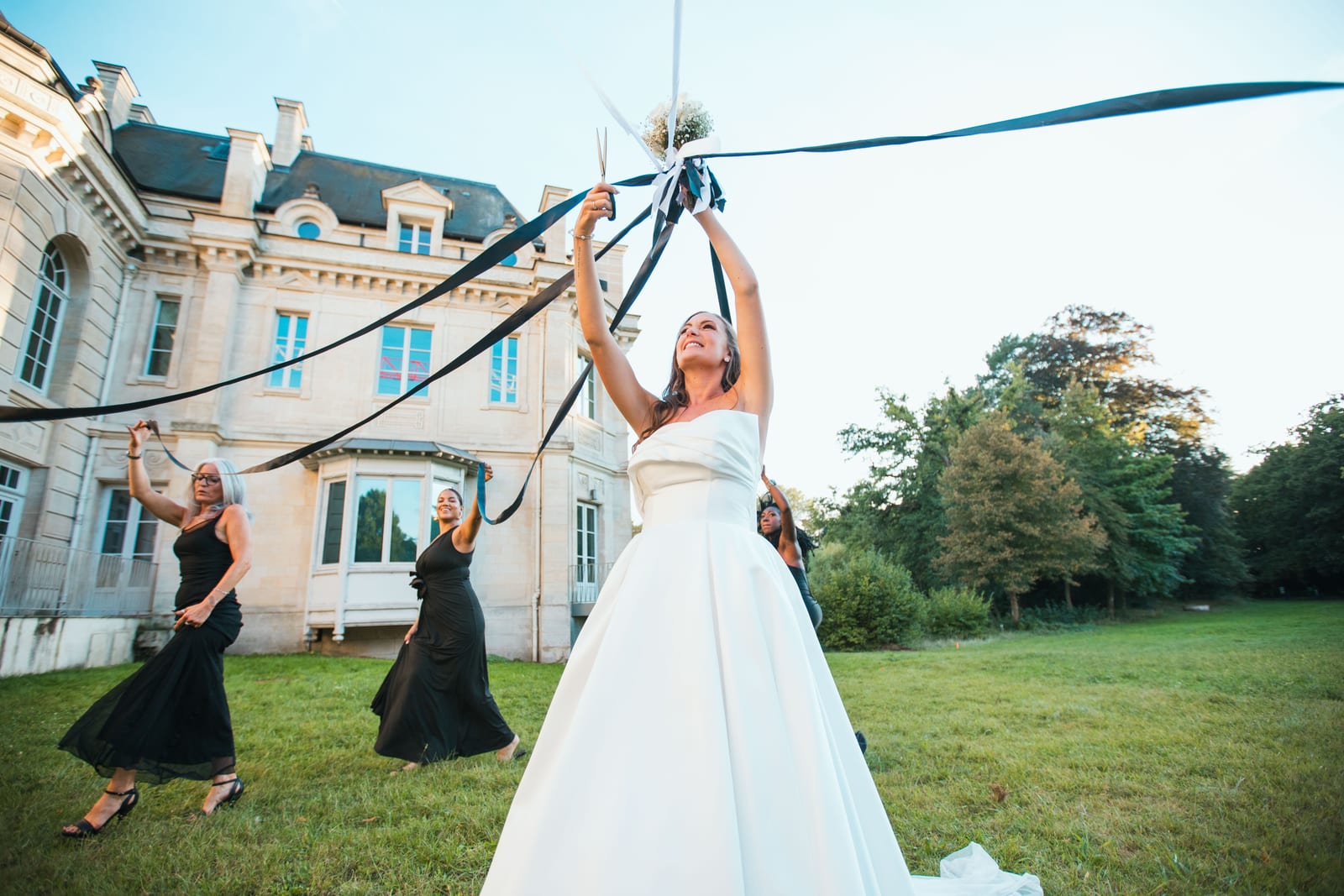 Wendy et Daniel en ouverture de bal, lumières scéniques colorées, couple au centre de la piste entouré des invités, mariage au Château de Lamorlaye, par Jean-Baptiste Argyre (Jaysphotography)