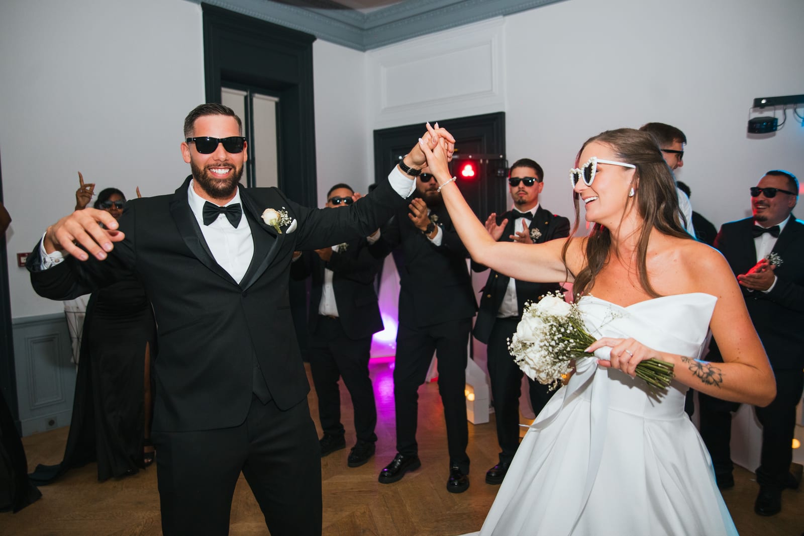 Wendy et Daniel en pleine danse d'ouverture de bal, mouvements fluides, robe blanche captée en mouvement sous l'éclairage scénique, mariage au Château de Lamorlaye, par Jean-Baptiste Argyre (Jaysphotography)