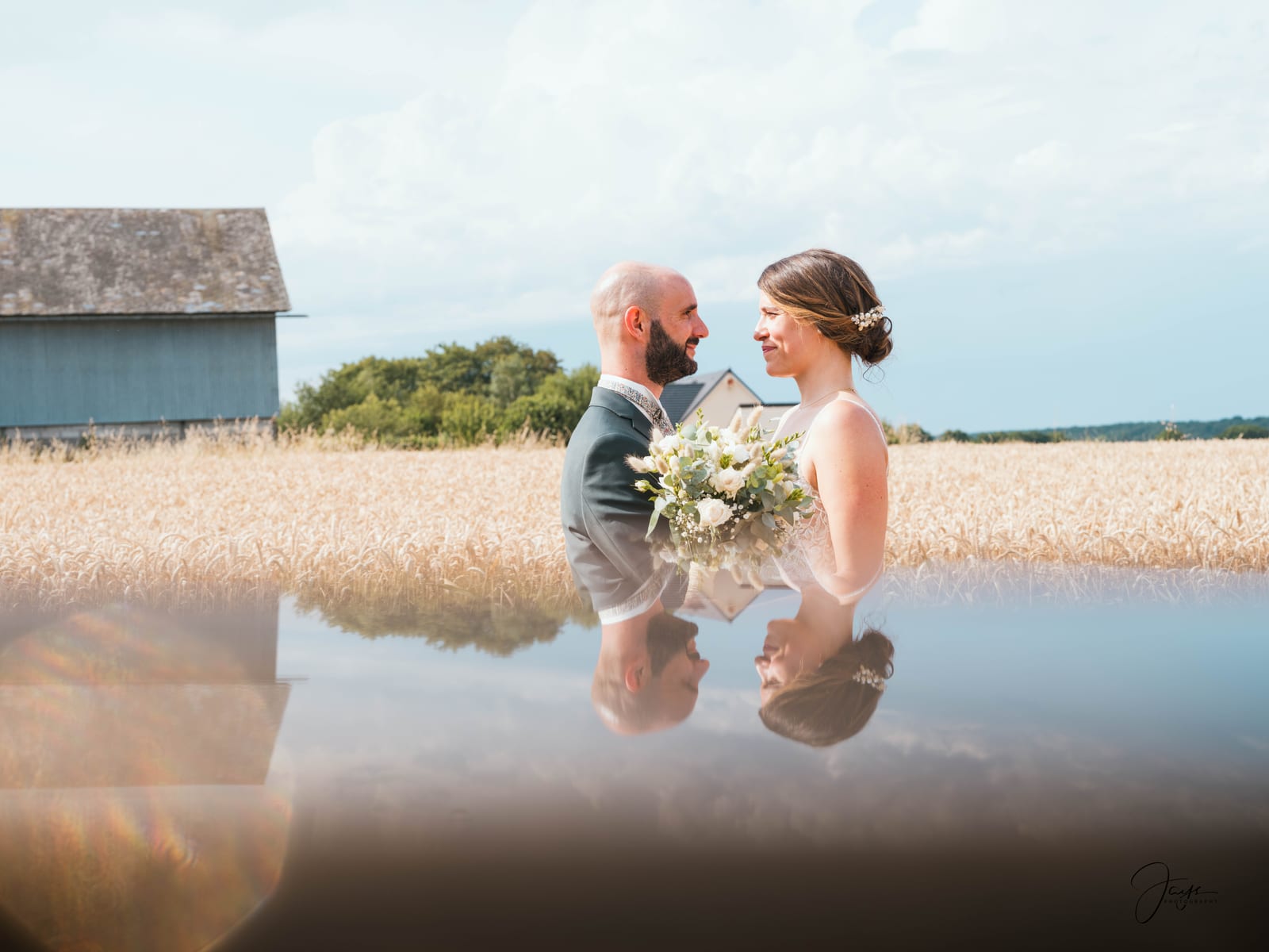 Groupe de mariés et invités avec reflet dans l'eau du Domaine de la Croix Sauvalle, mariage au Domaine de la Croix Sauvalle, par Jean-Baptiste Argyre (Jaysphotography)