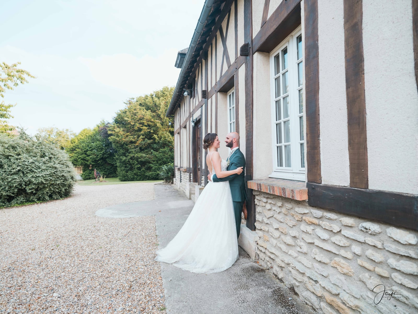Yohan et Julie devant la façade à pans de bois normande du Domaine de la Croix Sauvalle, mariage au Domaine de la Croix Sauvalle, par Jean-Baptiste Argyre (Jaysphotography)