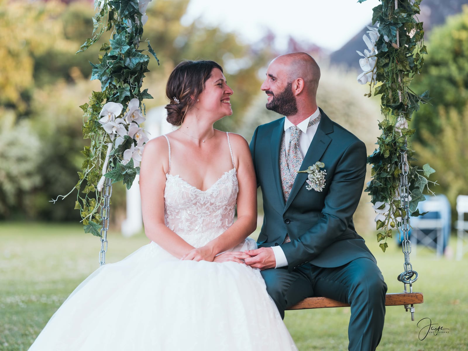 Yohan et Julie assis sur un banc dans le jardin du Domaine de la Croix Sauvalle, costume vert sauge, mariage au Domaine de la Croix Sauvalle, par Jean-Baptiste Argyre (Jaysphotography)